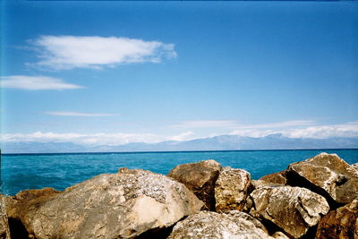 Rocks on sea shore against sky
