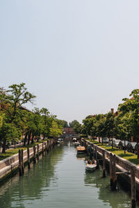 Boats in river against clear sky