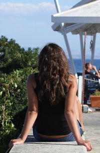 Rear view of woman sitting outdoors