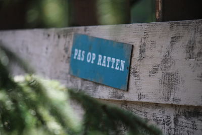 Close-up of text on wooden wall