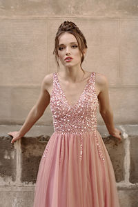 Portrait of young woman standing against wall