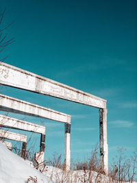 Low angle view of abandoned building against clear blue sky