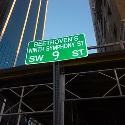 Low angle view of sign board against blue sky