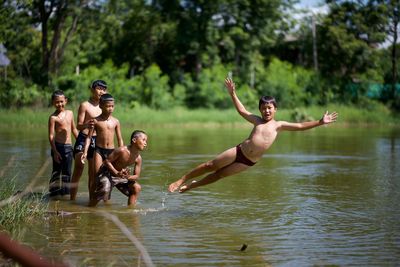 Young couple swimming in river at forest