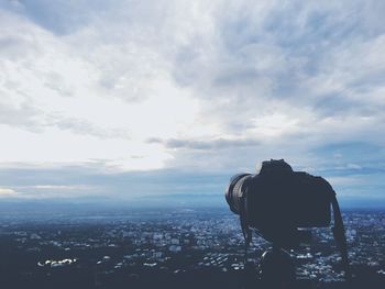 View of cityscape against cloudy sky