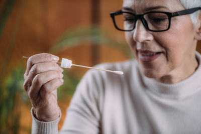 Close-up portrait of woman holding eyeglasses