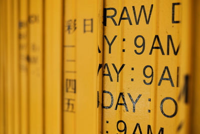 Retail business times displayed on orange metal wall