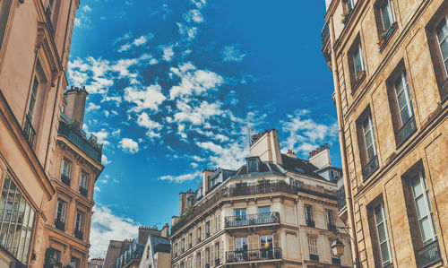 Low angle view of buildings against cloudy sky