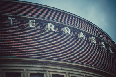 Low angle view of text on building against sky