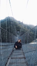 Man on bridge against sky