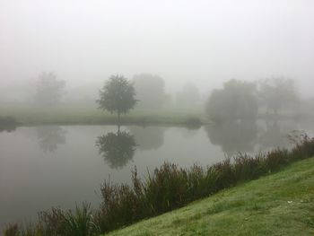 Scenic view of lake against sky during foggy weather