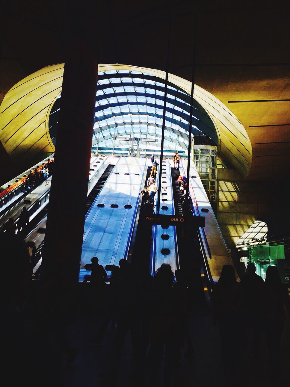 lifestyles, indoors, leisure activity, men, modern, architecture, built structure, person, arts culture and entertainment, low angle view, illuminated, standing, large group of people, reflection, glass - material, full length, medium group of people, casual clothing