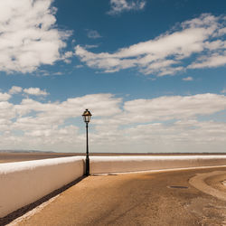 Street light on beach against sky