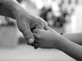 Close-up of father holding baby hand