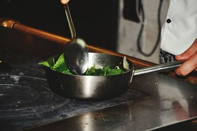 Midsection of person preparing food in kitchen