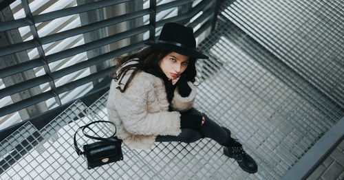 High angle portrait of woman sitting on steps