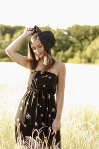 Woman wearing hat standing on field