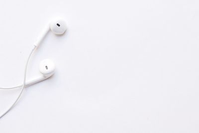 High angle view of in-ear headphones on white background