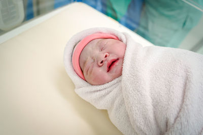 Portrait of cute baby boy sleeping on bed at home