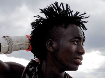 Side view of young man against sky