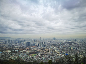 High angle view of cityscape against cloudy sky