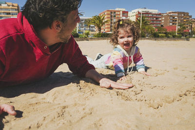 Side view of man sitting on beach