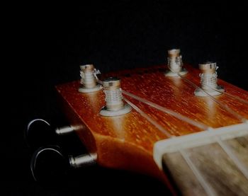 Close-up of guitar on table against black background