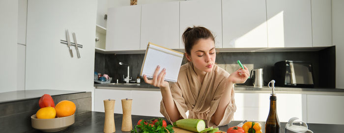 Portrait of young woman preparing food at home