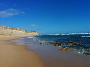 Scenic view of beach against blue sky