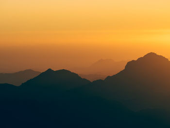 Scenic view of silhouette mountains against sky during sunset