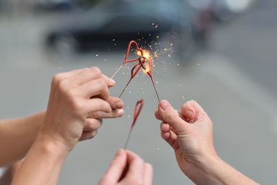 Close-up of cropped hands holding sparklers