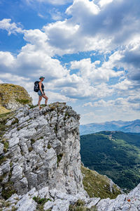 Rear view of man walking on mountain against sky