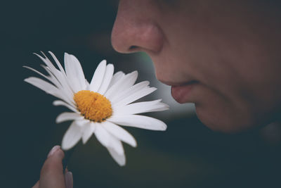 Close-up of woman smelling white flower