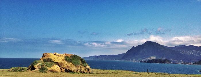 Scenic view of mountains against blue sky