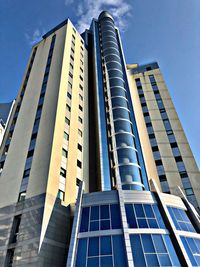 Low angle view of modern building against blue sky