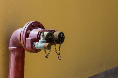 Close-up of fire hydrant against wall