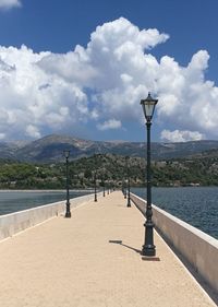 Scenic view of sea by mountains against sky