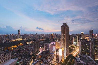 Aerial view of illuminated buildings in city against sky