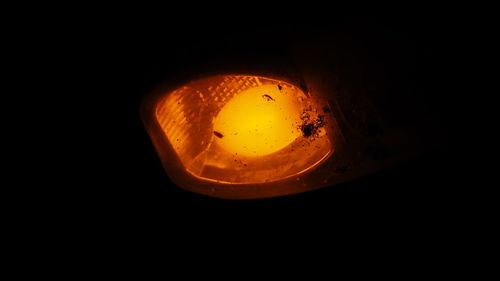 Close-up of illuminated candle against black background