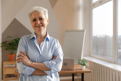 Portrait of young woman standing in office