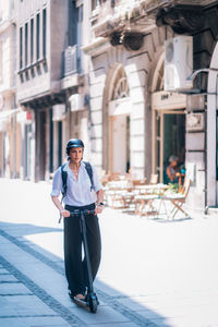 Woman riding electric push scooter on road