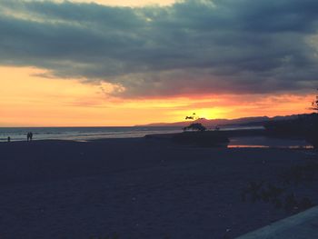 Scenic view of beach against sky during sunset