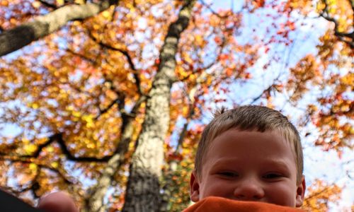 Portrait of boy with leaves during autumn