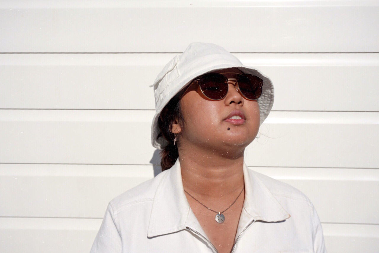 PORTRAIT OF MAN WEARING SUNGLASSES AGAINST WALL