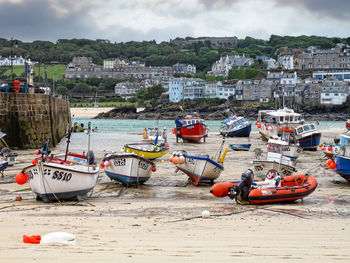 Boats moored at beach against buildings