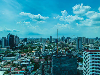 High angle view of modern buildings against blue sky