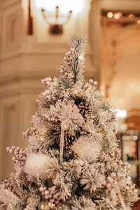 A traditional snow covered christmas tree, decorated with snowflakes and forest cones.