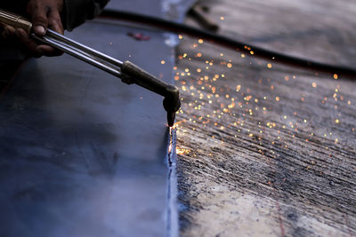 Cropped hand welding metal in workshop