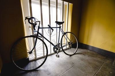 Bicycle parked against wall of building