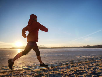 Woman run on the beah. winter sports outdoor fitness workout health concept.